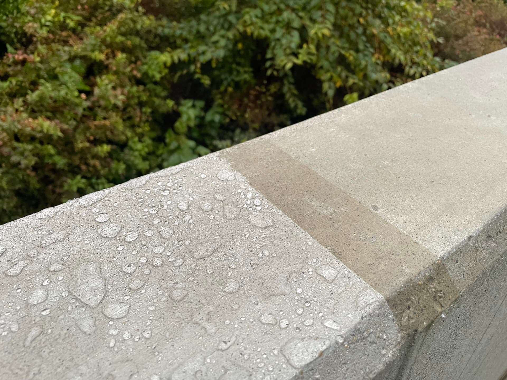 Klare Kante zwischen behandelt (links, Tropfenbildung) und unbehandelt (rechts, durchfeuchtet und fleckig).