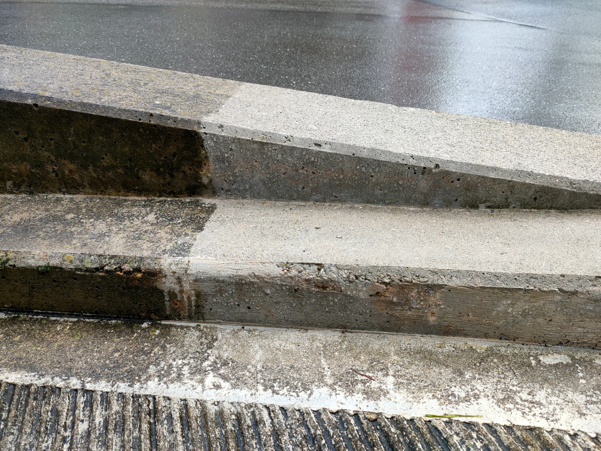 Betontreppe nach Jahren im Freien: der behandelte Bereich bleibt sauber, der unbehandelte zeigt Algen-, Moos- und Schmutzbefall.